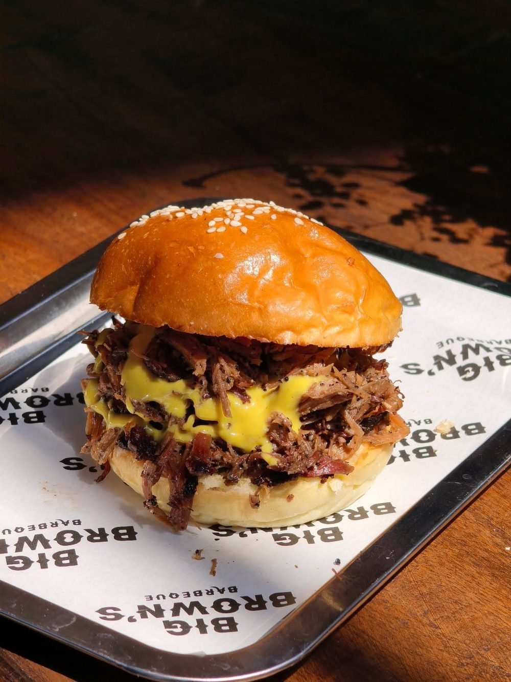 The OG Brisket Burger: pulled smoked brisket and sauce on a sesame bun, served on a Big Brown's tray