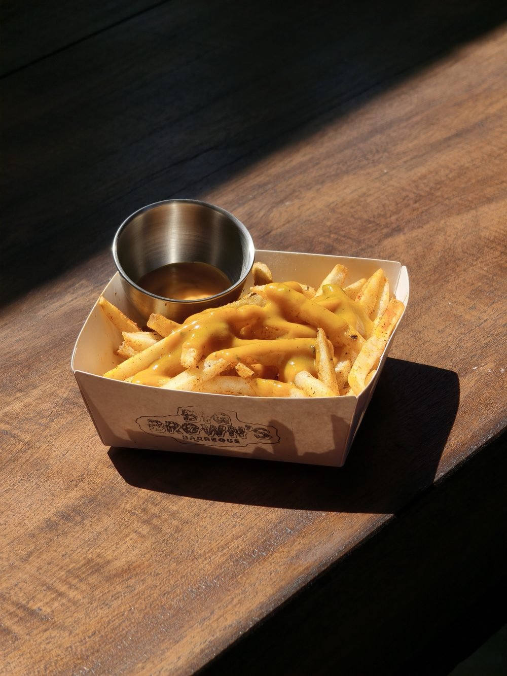 Seasoned fries with cheese sauce and a dip